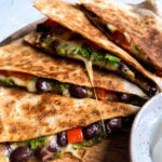 kale and black bean quesadillas layered on a wooden plate