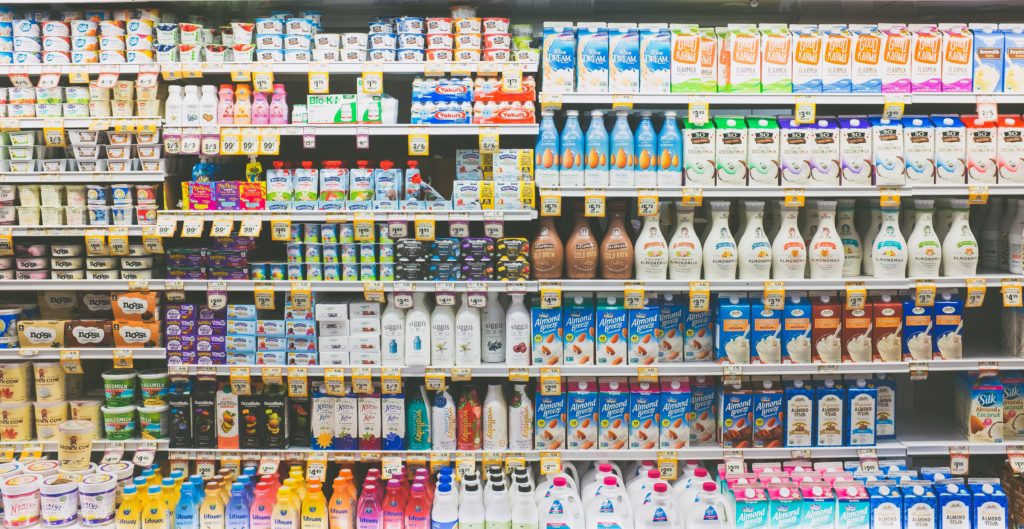 assorted non-dairy milk in grocery store refrigerator