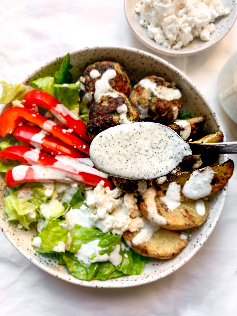 creamy feta yogurt sauce on a spoon