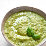 garlic scape and basil pesto in a bowl on a white background