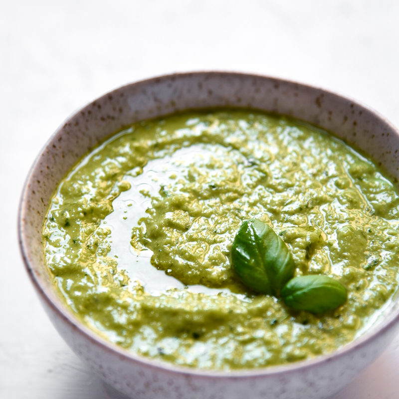 garlic scape and basil pesto in a bowl on a white background