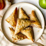 apple cinnamon turnovers piled on a plate