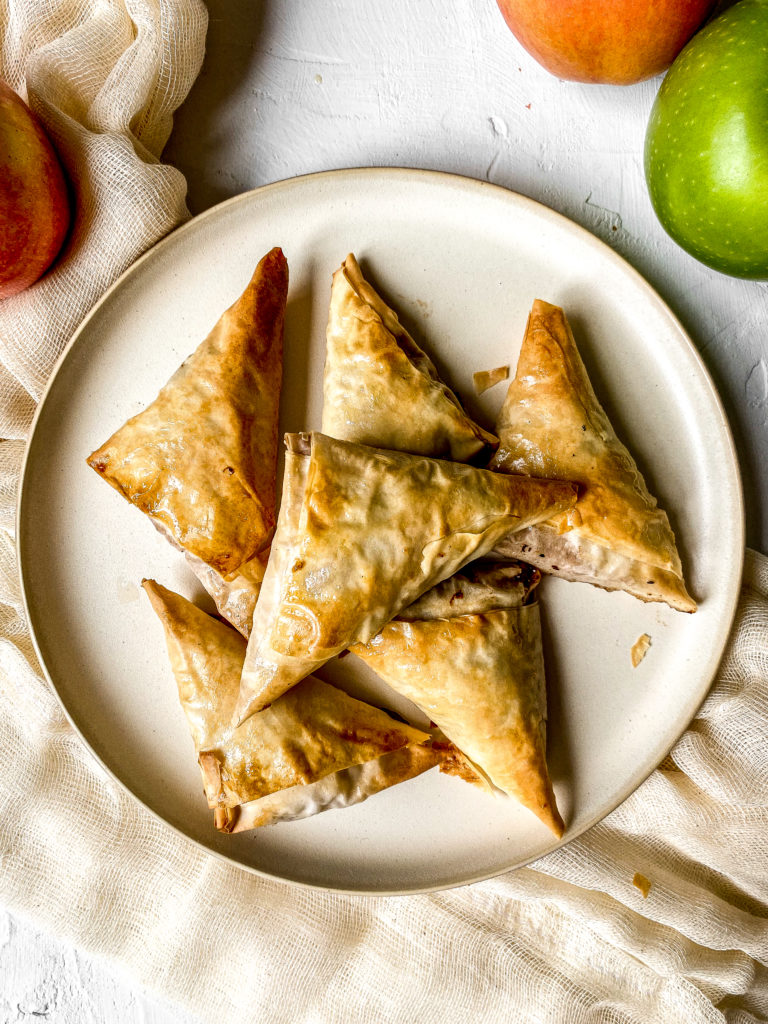 apple cinnamon turnovers piled on a plate