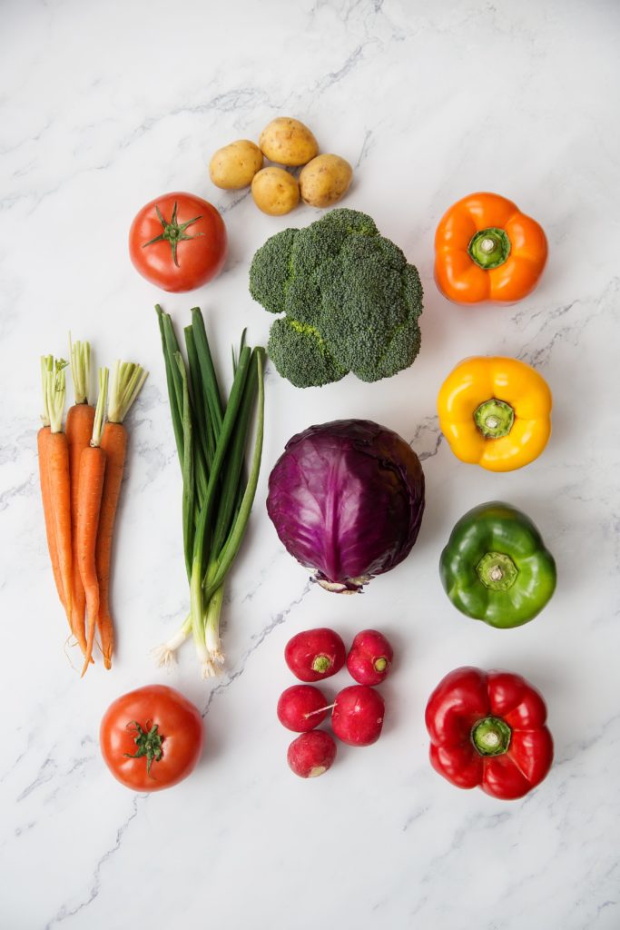 flatlay of color vegetables on marble surface