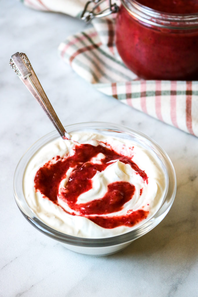 plain yogurt in a glass bowl swirled with chia jam