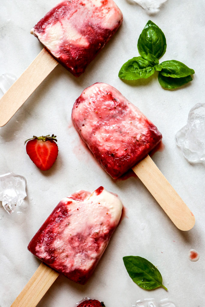 strawberry basil swirl yogurt popsicles laying in a verticle line