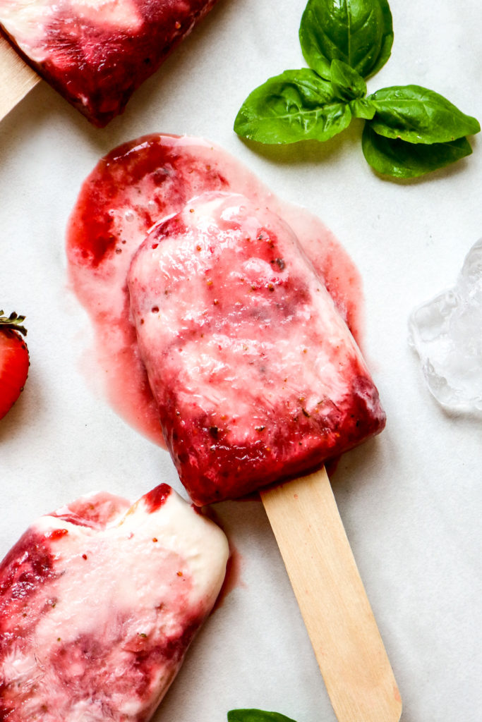 a yogurt popsicle laying in a pool of melted popsicle