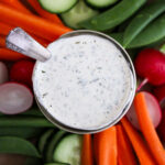 overhead shot of a jar of ranch dressing surrounded by a rainbow of vegetables