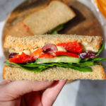 cross-section view of a sandwich being held over top of the plate