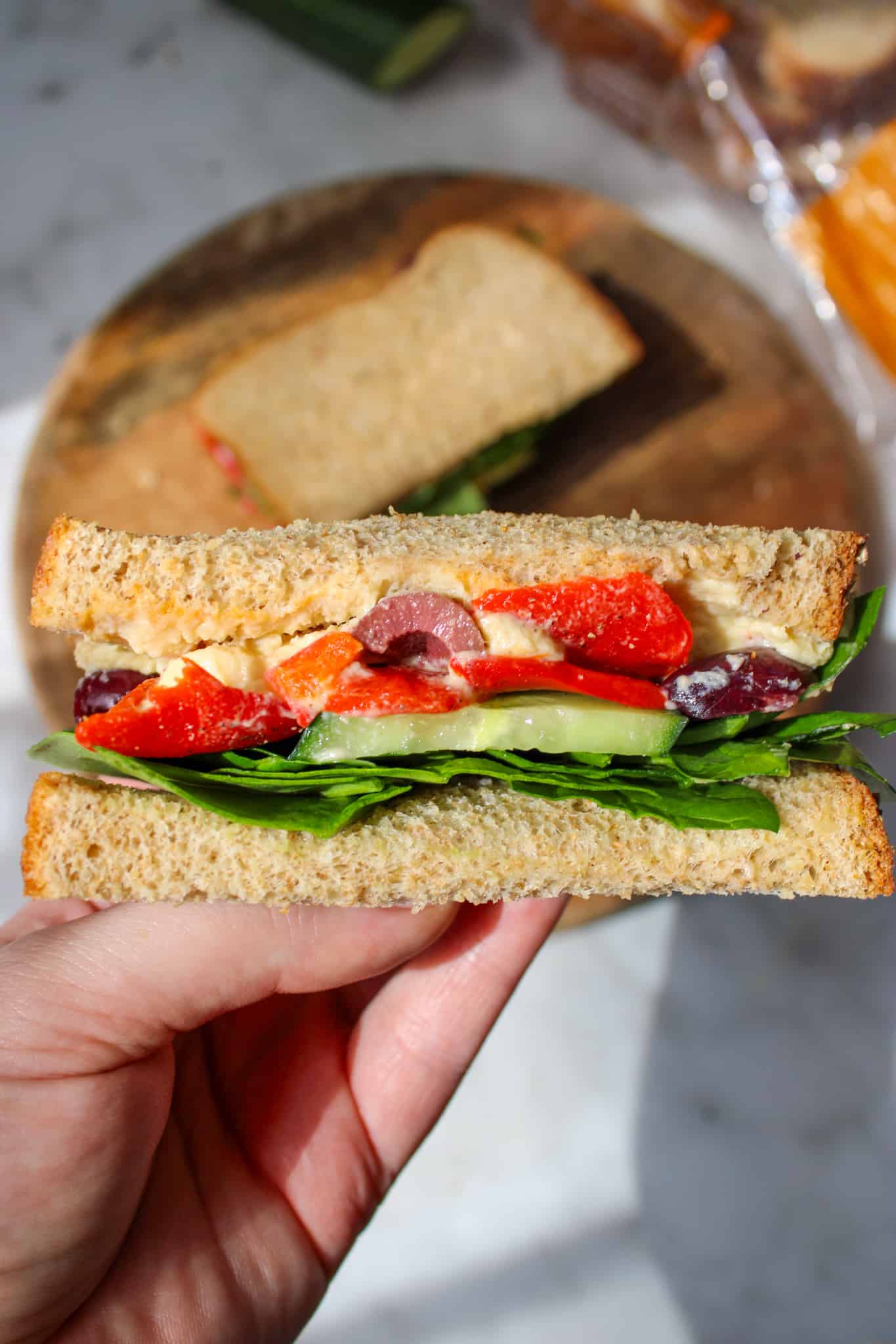 cross-section view of a sandwich being held over top of the plate