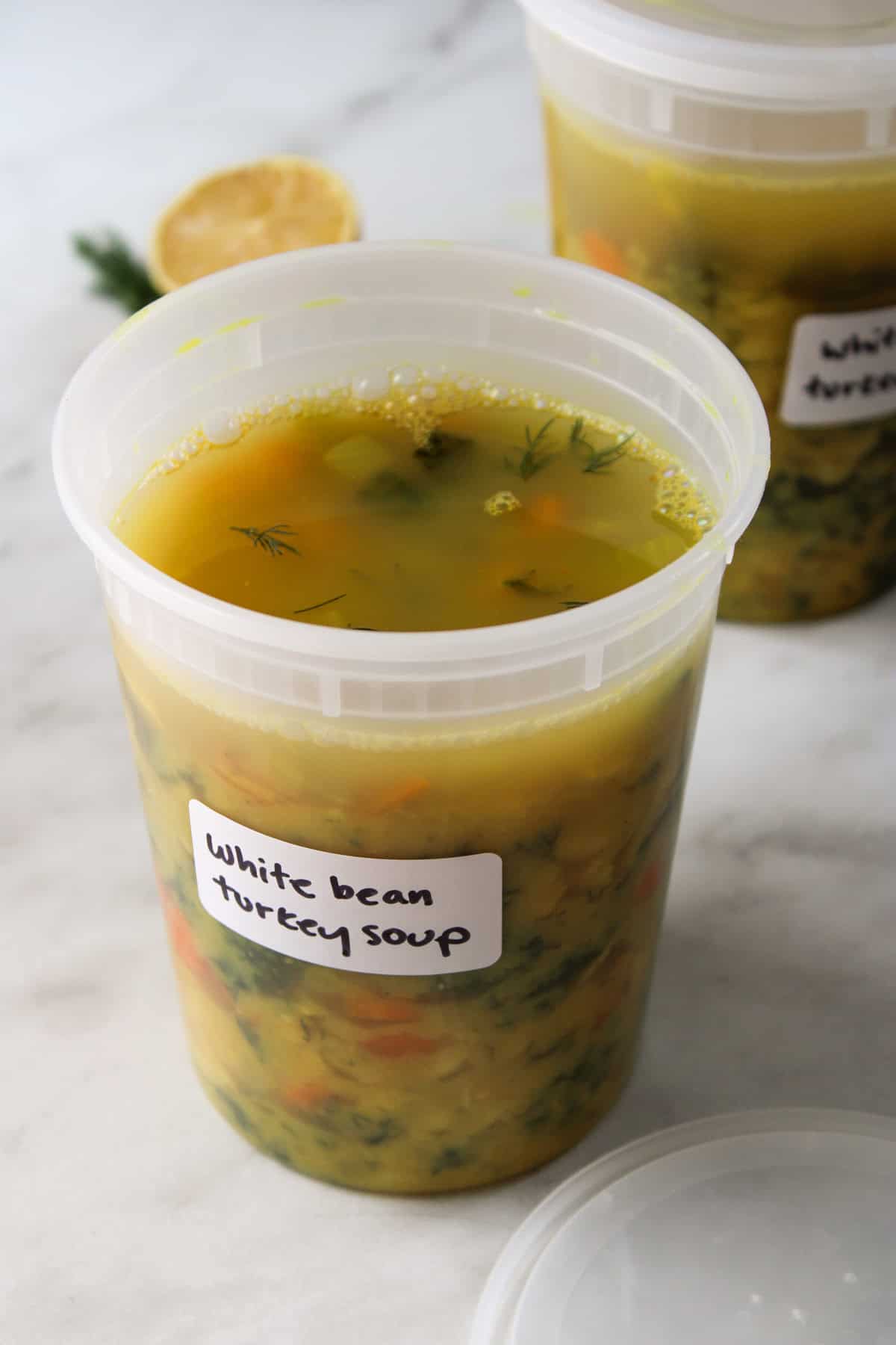 soup in a plastic quart container with a white label reading "white bean turkey soup"