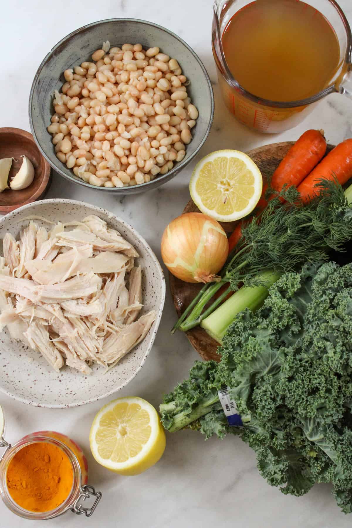 ingredients for soup placed on a marble countertop